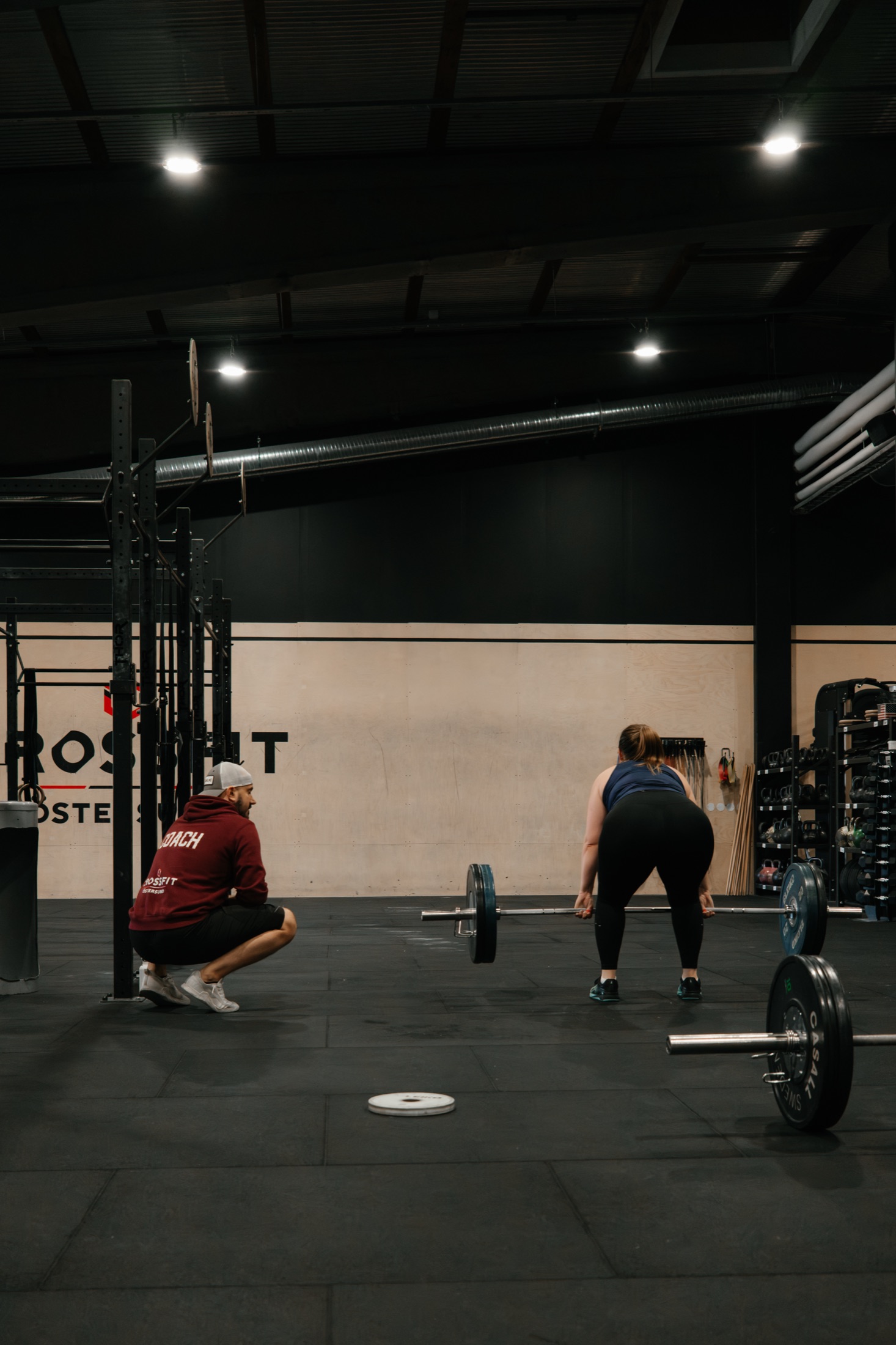 Coach supporting an athlete during a lift